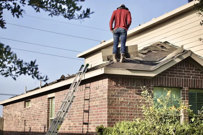Professional roofer working on a residential roof in Maryland Park